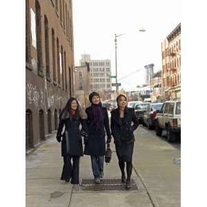  Three Young Asian Women Walk Down a City Street Conversing 